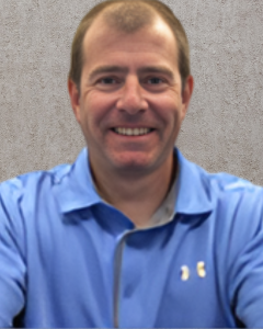 NICHOLAS CORCORAN | OHIO811 Portrait of a smiling man in a blue polo shirt against a beige textured background.